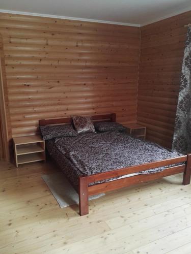 sypialnia z łóżkiem w drewnianej ścianie w obiekcie Гірський релакс w mieście Golovetsk