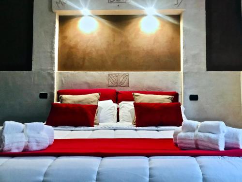 een groot wit bed met rode en witte kussens bij B&B mò•sì in Massa dʼAlbe