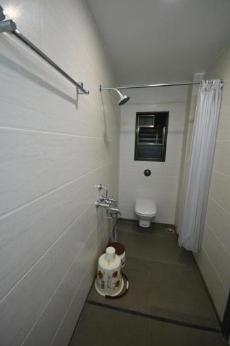 a bathroom with a toilet and a shower stall at Hotel Dhantara in Shirdi
