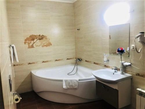 uma casa de banho com uma banheira e um lavatório em Sultan Beibarys em Astana