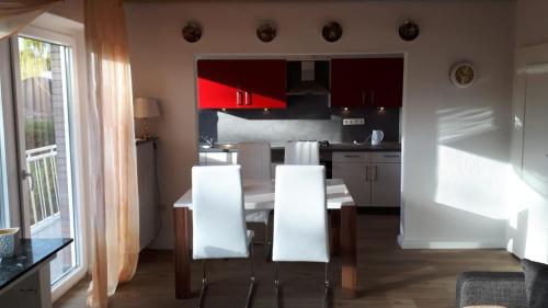 uma cozinha com mesa e cadeiras num quarto em Ferienwohnung Gesine em Leer