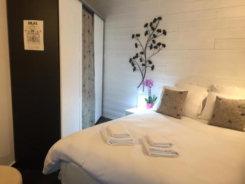 um quarto com uma grande cama branca com duas toalhas em Tu Casa parking fibre optique Netflix em Saint-Raphaël