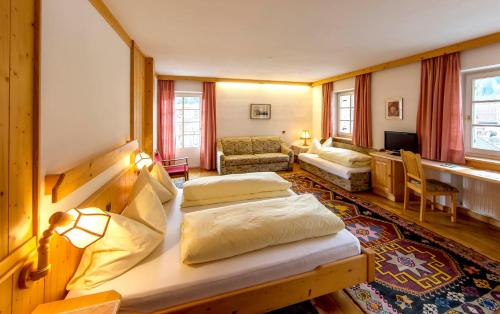 a bedroom with two beds and a living room at Gasthof Obermair in Chienes