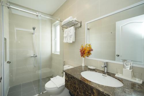 a bathroom with a sink and a toilet and a shower at Park Hill Hotel - Phu My Hung in Ho Chi Minh City