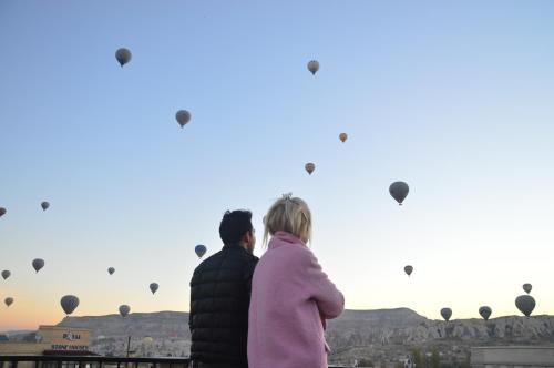 a man and a woman looking at hot air balloons at Cappadocia Elite Stone House in Goreme