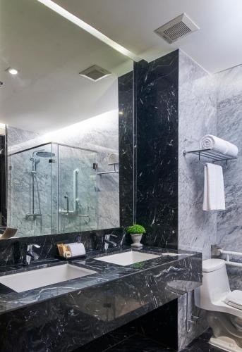 a bathroom with two sinks and a glass shower at Amp Am House Bangkok Hotel in Bangkok