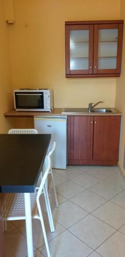 a kitchen with a black table and chairs and a microwave at Guesthouse Villa Joanna&Mattheo in Sarandë