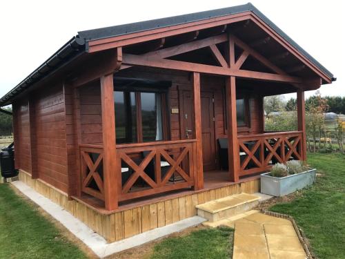 a large wooden cabin with a large window at Northwick Farm Lodges in Broadway