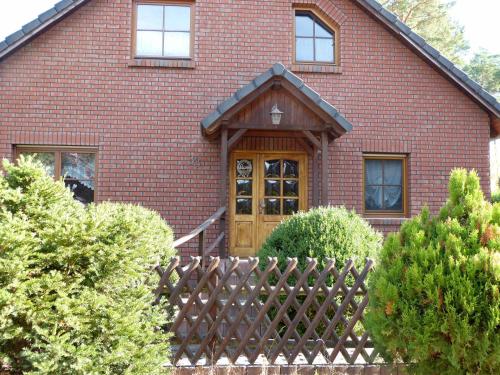 a red brick house with a wooden door at Auf der Heide in Borkheide