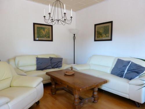 a living room with two white couches and a coffee table at Auf der Heide in Borkheide