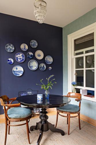 a dining room with blue and white plates on a wall at B&B Noordwijk Binnen in Noordwijk