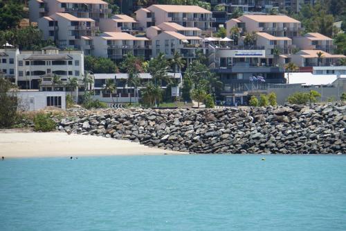 a view of a beach with buildings in the background at Airlie Seaview Apartments in Airlie Beach