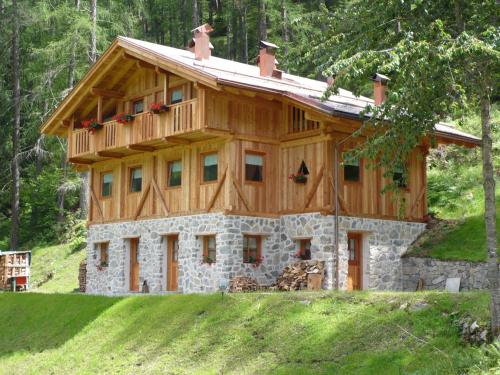 a log cabin with a wooden roof at Mas De La Bolp - Chalet in Rabbi