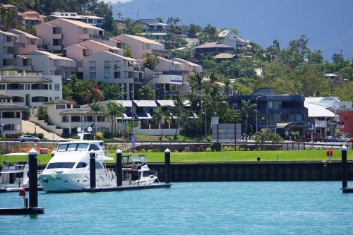 a boat docked at a dock in the water at Airlie Seaview Apartments in Airlie Beach