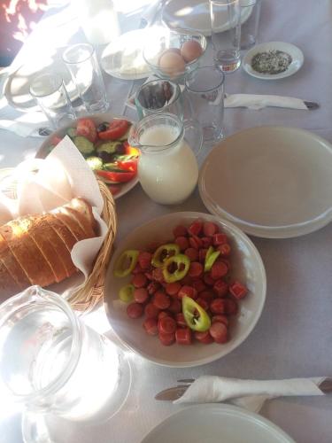 a table with a plate of food and a bowl of fruit at Guesthouse Villa Joanna&Mattheo in Sarandë
