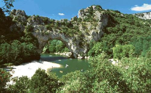 a river with a bridge in the middle of a mountain at Suite Nid d'Amour et Spa privatif in Vogüé
