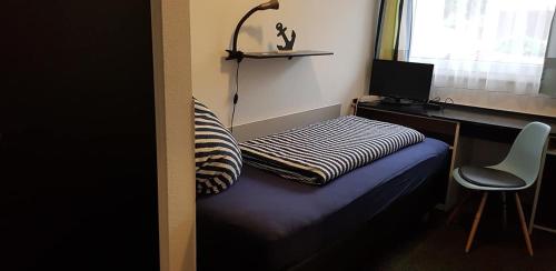 a bedroom with a bed and a desk and a chair at Hotel Garni in Herborn