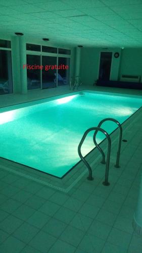 a swimming pool in a building with a lit up swimming pooliteratoriteratorythonython at Le Repaire du Golfeur de la Largue - Mooslargue in Mooslargue