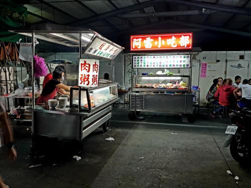 a food cart with a person preparing food in a market at MILU Backpacker Hostel in Puli