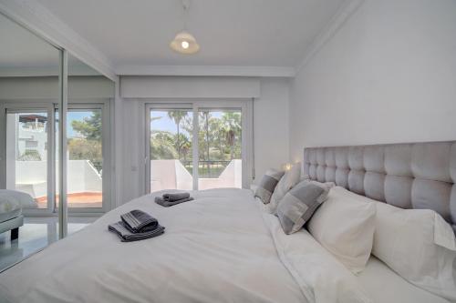 マルベーリャにある3 bed Modern House Marbella - Direct Pool Accessのベッドルーム(白い大型ベッド、本付)