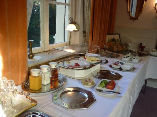 einen Tisch mit Teller mit Lebensmitteln drauf in der Unterkunft Hotel Waldfriede in Darmstadt