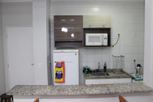 una cucina con frigorifero bianco e forno a microonde di Olímpia Temporada Cond. Villagio a Olímpia