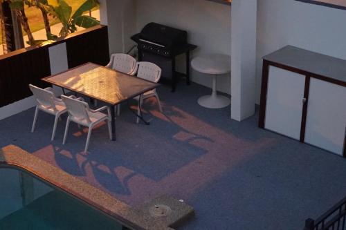 a room with a table and chairs and a piano at Airlie Seaview Apartments in Airlie Beach