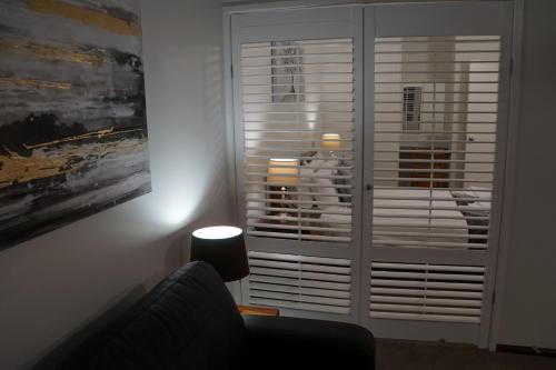 a living room with a large window with blinds at Airlie Seaview Apartments in Airlie Beach