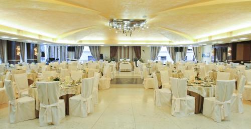 a large banquet hall with white tables and chairs at Grand Hotel President in Siderno Marina