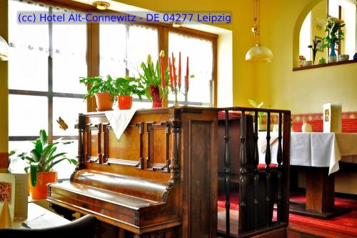 a restaurant with a piano in a room with plants at Hotel Alt-Connewitz in Leipzig