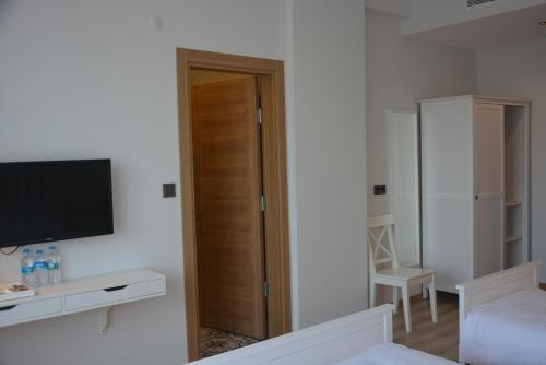 a living room with a television and a room with a door at Eleia Hotel İznik in Bursa