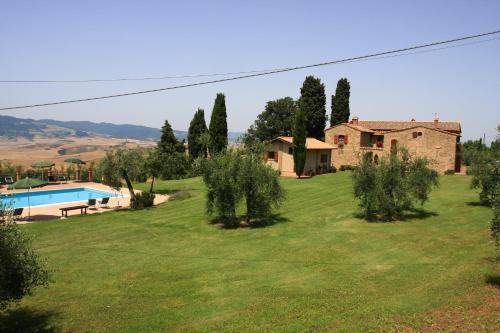 un gran patio con una casa y una piscina en Agriturismo Villa Opera en Volterra