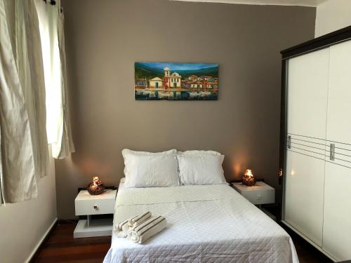 a bedroom with a white bed with two candles on it at Apartamento 3 quartos Rio in Rio de Janeiro