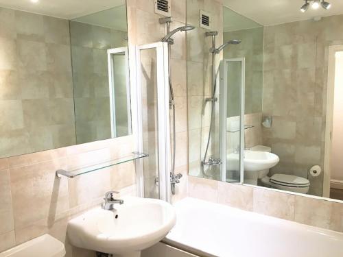 a bathroom with a sink and a toilet and a mirror at Elegant Very Central: Fitzrovia W1. King Bed, Wifi in London