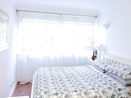 a white bedroom with a bed and a window at Elegant Very Central: Fitzrovia W1. King Bed, Wifi in London