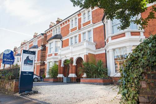 a large brick building with a sign in front of it at The Blue Piano Guesthouse in Birmingham