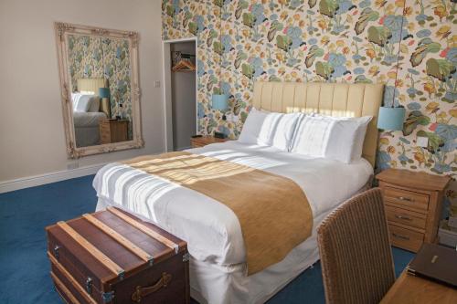 1 dormitorio con 1 cama grande y espejo en The Blue Piano Guesthouse en Birmingham