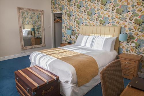 a bedroom with a large bed and a mirror at The Blue Piano Guesthouse in Birmingham