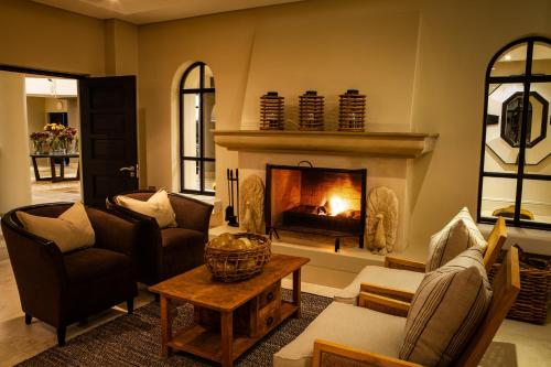 a living room with a fireplace and couches at Santé Wellness Retreat & Spa in Paarl