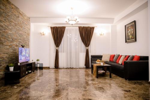- un salon avec un canapé et une télévision dans l'établissement Sun Residences Intercontinental, à Bucarest