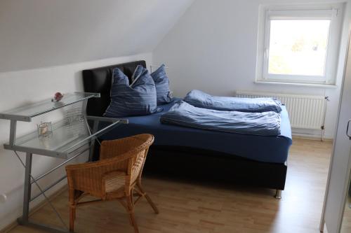 フェルバートにあるGemütliche Wohnungのベッドルーム1室(青いシーツとガラスのテーブルが備わるベッド1台付)
