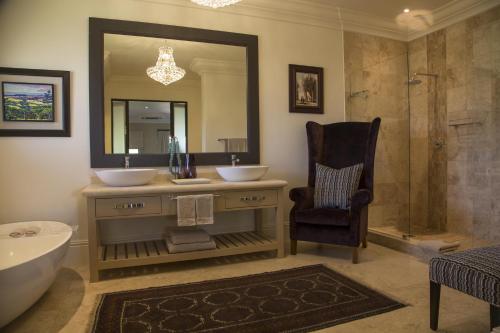 a bathroom with a tub and a sink and a mirror at Santé Wellness Retreat & Spa in Paarl