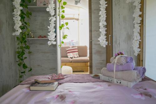 a bedroom with a bed and a mirror and flowers at Ciriga Sicily Glamping in Santa Maria Del Focallo