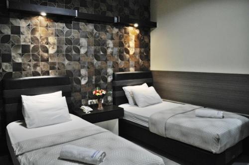 una habitación de hotel con 2 camas y flores. en Grand Krakatau Hotel Serang, en Serang