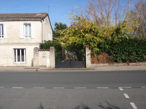 a house on the side of a street with a fence at La Maison d'Alienor in Saint-Médard-de-Guizières