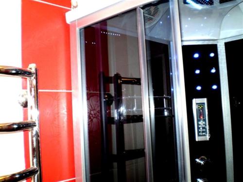 a mirror in a bathroom with a red wall at 1 ком квартира Соборная-Макарова Wi-Fi, Макдональдс, самый центр Николаева 2 дивана 2 этаж in Mykolaiv