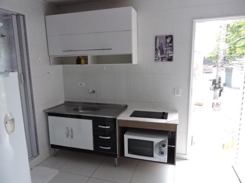 a kitchen with a sink and a microwave at 10 Studios in Sao Paulo