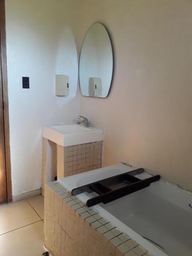 een badkamer met een wastafel en een spiegel bij SeaXplore Lodge & Dive Center in Sodwana Bay