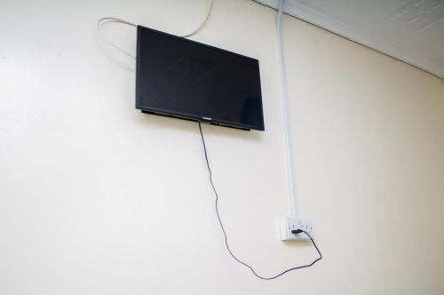 a flat screen tv hanging on a wall at Rugems Executive Lodge in Lusaka