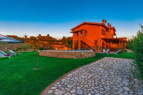 a house with a stone walkway in front of a house at Casale La Desdemona in Sutri